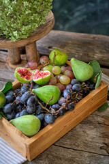 Wooden box with grapes and figs. Summer, seasonal fruits