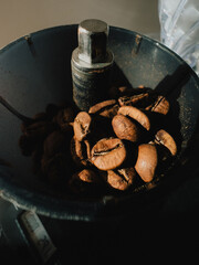 Roasted coffee beans resting inside dark grinder, waiting to be transformed into aromatic coffee powder, filling air with rich, invigorating aromas perfect for brewing. Dark grinder, coffee beans