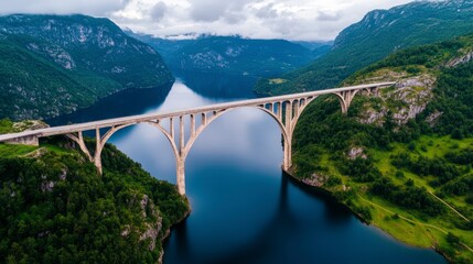Fototapeta premium Breathtaking View of an Architecturally Designed Bridge Over a Serene Lake Surrounded by Majestic Mountains