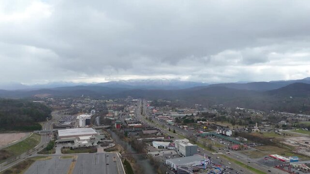 Aerial shot over Piegon Forge, TN with snow covered Smoky Mountains in the background.