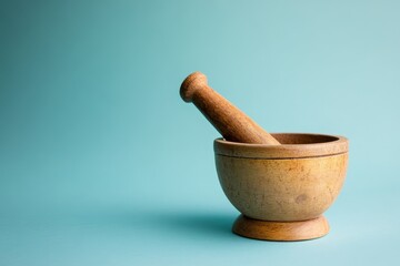 A wooden mortar and pestle resting on a light background