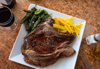 Entrecote with potatoes and stewed peppers on a plate