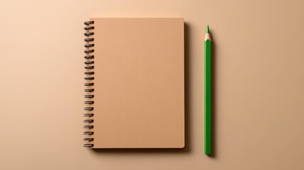 Minimalist notebook paired with green pencil on beige background
