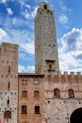 Torre Grossa rises majestically in the heart of San Gimignano, Italy, surrounded by historic buildings and a stunning blue sky, showcasing the region's architectural heritage.