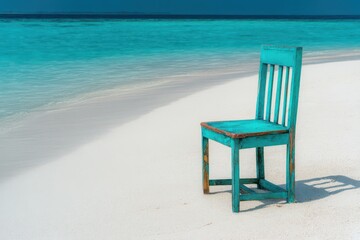 Beautiful turquoise wooden chair on the white sand beach