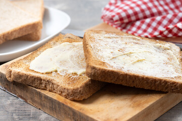 Sliced fresh bread and butter on wooden table