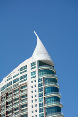 Modern architectural marvel stands tall against the clear blue sky in a vibrant urban setting