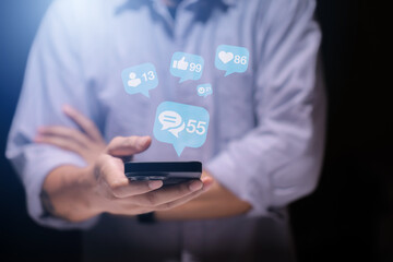 Close-up of man's hand using smartphone to play social media with emoticons or notifications popup.	
