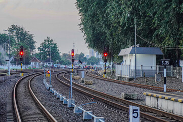 A view of the railway tracks with traffic signals and a signal tower at a train station in...