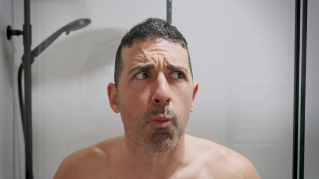 Man rinsing mouth with water and spitting in the sink.