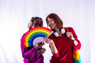 Two smiling women holding rainbow fan celebrating pride and diversity