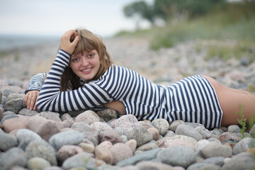 Young sexy woman in vest on wild beach
