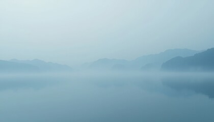 Obraz premium Tranquil misty morning over a serene lake nature landscape calm waters panoramic view peaceful atmosphere for relaxation and reflection