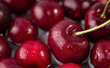 Fresh red cherries covered in water droplets, close-up photography style, on a dark background. Concept of freshness and healthy eating for banner or advertising of food. Top view.