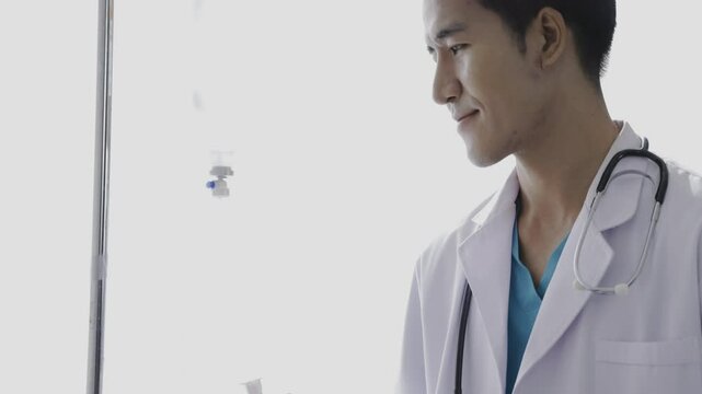 The doctor is examining the patient's saline solution. hand holding saline IV drip for patient in hospital room.