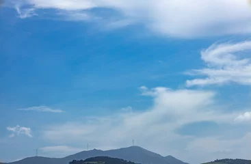 Mountains amidst distant mist with huge power-generating fans.