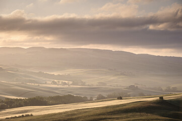 Misty sunrise over the rolling hills of Tuscany, Italy. Val d’Orcia.