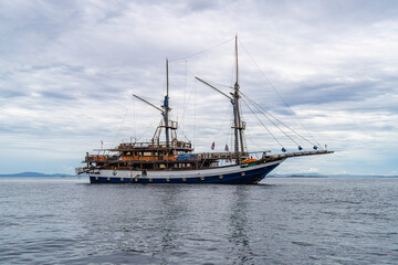 Elegant traditional boat floating on still ocean water in exotic Indonesian seascape