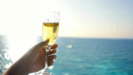 Celebratory toast at sea: hand raising champagne glass against ocean horizon in dynamic journey of elegance and tranquility