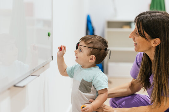 Baby boy wearing eye patch playing during eye exam with doctor