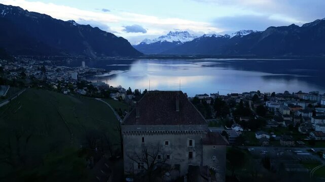 Dolly out drone shot close to Chatelard Castle, Dents du Midi and Lake Geneva at sunset in Montreux, canton of Vaud, Switzerland