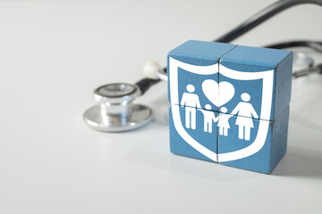 Family health insurance icon on wooden blocks with stethoscope on white background. Concept for...