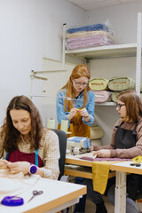 Three women seamstresses and fashion designers work in for sewing machines, clothing production, business. Professional female tailors are working on collection of clothes. overtime work.