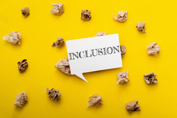 Yellow background with a white sign that says inclusion