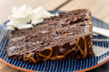 Portion of chocolate tart with almonds and caramel in dark plate restaurant in Canary islands Spain