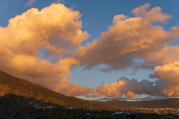 Fototapeta premium Orange clouds at sunset in La Palma, Tazacorte, with banana trees below. La Palma island Canary archipelago Spain