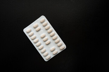 Medicine package in front of black background. 25 pills.