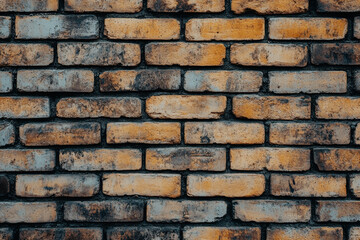 Obraz premium Detailed view of a textured brick wall with various shades of brown and yellow in an indoor setting during daylight hours