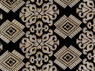 Graphic background in random ethnic ornamental pattern. Black and beige gold fabric or wallpaper in...