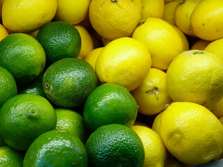Containers with fresh fruits in the store, lemons and limes, background