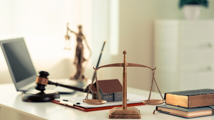 Miniature house, foreclosure auction, lawyer, wooden hammer on table with blurred house in background. Real estate auction and foreclosure concept