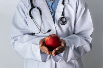 Doctor holding a red apple in her hands - Concept healthy food.