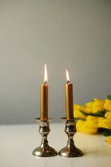 vertical photo Shabbat scene with two lit Sabbath candles in silver candlesticks, a glass of red wine. Shabbat Shalom