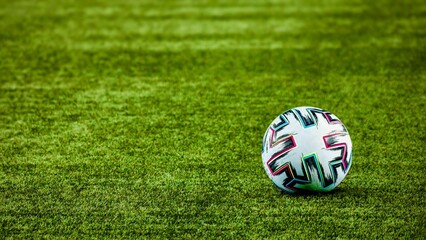 A soccer ball on the green grass for background 