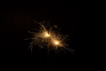 Fototapeta premium golden sparklers of bengal sparklers on a black background
