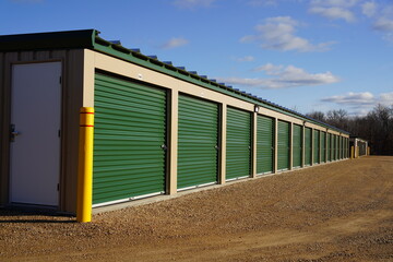 Green and tan storage units are being used to hold rental property and belongings.