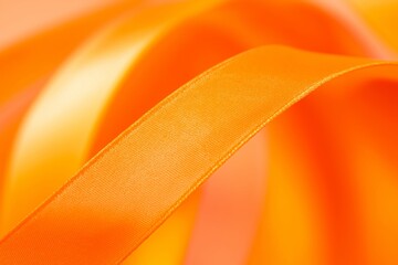 A close-up of an orange ribbon twisting and turning, representing creativity and playful elegance.