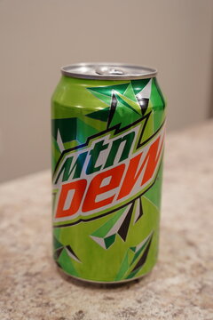  A can and glass of Mountain Dew soda sit on the kitchen countertop.