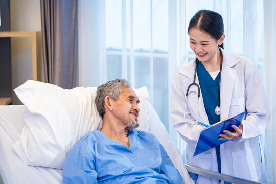 Asian doctor is explaining the x-ray film to senior patient who suffering from lung cancer in the hospital wing for long term smoking disease and care plan surgery program