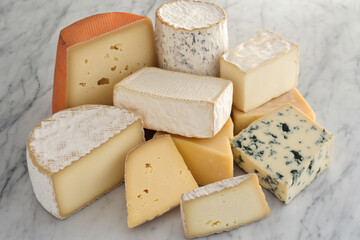 Assorted Cheese Pile: A collection of various cheese types stacked against a marble background.