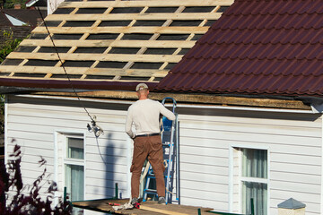 Installation process of metal roofing on a residential building in the afternoon