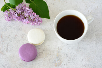 flat lay with a cup of coffee, macarons and a branch of blooming lilac