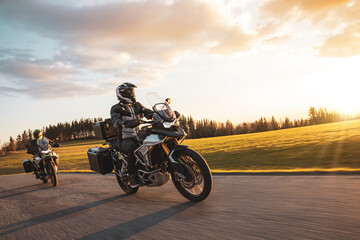 Two Drivers Riding Motorcycle on Empty Road During Sunset. Travel in Nature. Beautiful Evening...