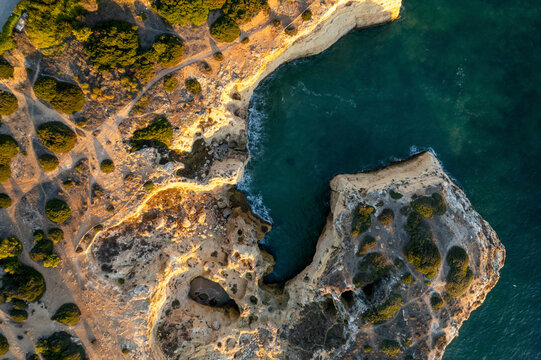 Aerial view of rugged cliff beach with rocks and the Atlantic Ocean, Algave, Portugal.