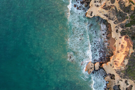 Aerial view of beautiful cliff beach with rocky coastline and turquoise ocean, Algave, Portugal.