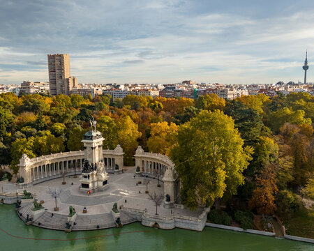 Aerial view of Parque el Retiro with Monumento a Alfonso XII surrounded by lush greenery and tranquil water, Retiro, Madrid, Spain.